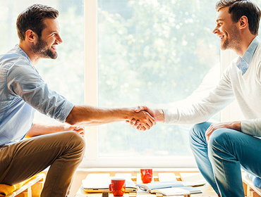 Two people shaking hands at a meeting